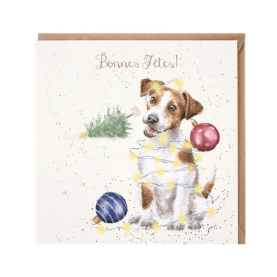 Jack Russell covered in fairy light and baubles with a fallen Christmas tree in background French Christmas card