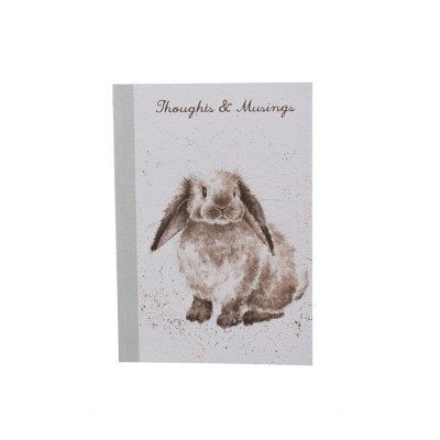 Fluffy grey Rosie rabbit on an A6 paperback notebook