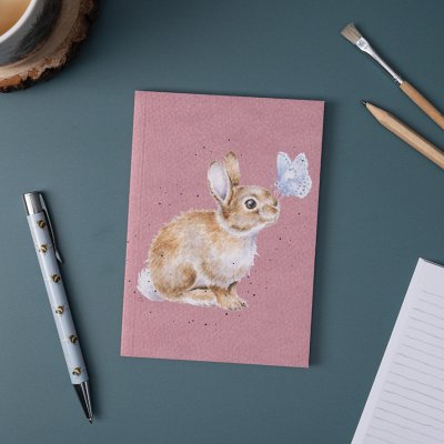 A rabbit with a butterfly on nose on an A6 paperback notebook